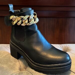 H by Halston black boots with big gold link chain detail.